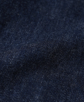 Indigo denim fabric texture detail with subtle contrast stitching