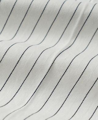 White pinstripe fabric close-up with vertical blue lines and subtle weave texture