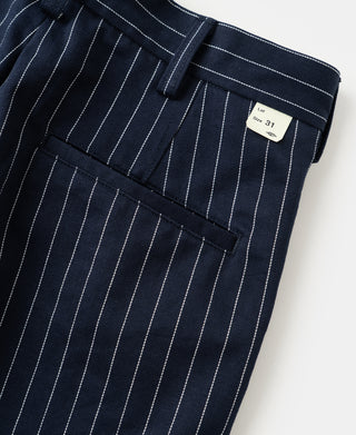 Navy pinstripe work pants with stitched waistband, belt loops, and size tag