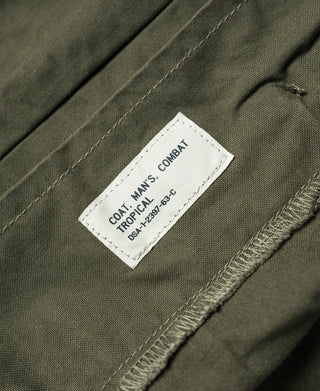 Olive jacket with white fabric label: COAT MANS COMBAT TROPICAL