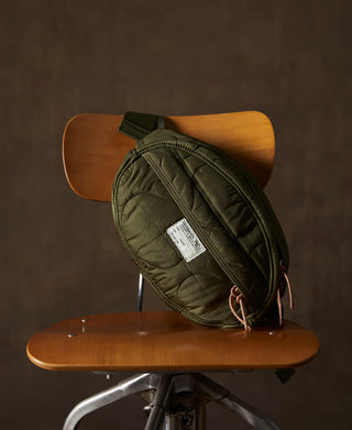 Olive waist bag with side zipper, adjustable strap, and rectangular product label
