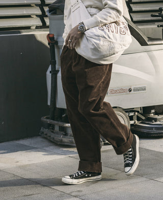 Brown corduroy trousers with straight legs and relaxed waistband, side view