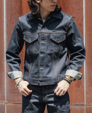 Indigo denim jacket with flap chest pockets, button front, and stitched panels