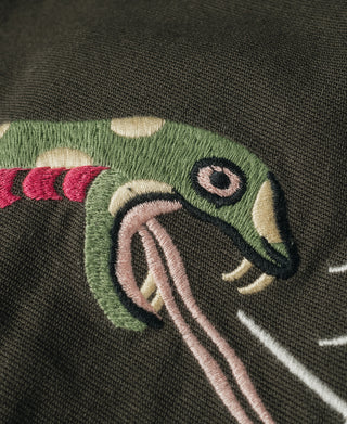 Embroidered snake face with green head and pink tongue on dark gray-green jacket