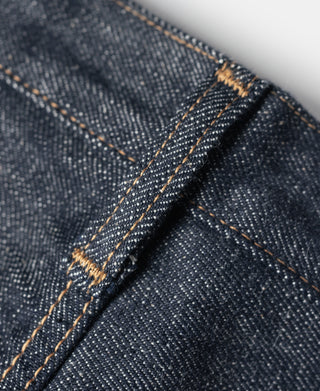 Dark denim jeans pocket corner with tan topstitching and bartack reinforcement