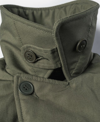 Olive jacket cuff and pocket tab showing two snap buttons