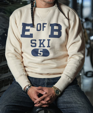 Apricot crewneck sweater with blue 'E OF B' ski graphic and ribbed cuffs