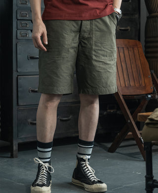 Olive fatigue utility shorts with straight legs and cargo pocket flaps