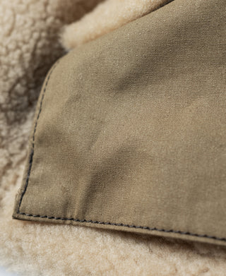 Cream shearling cuff with stitched edge on a dark brown leather flight jacket