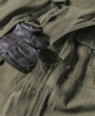 Olive utility jacket front close-up with flap chest pockets and metal buttons