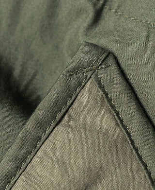 Olive M-65 parka inner pocket panel with top stitch and tie cord ends