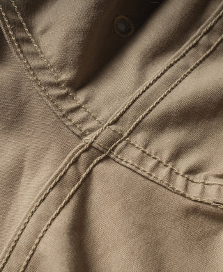 Khaki jacket front placket with button closure and detailed stitching
