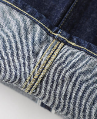 Indigo denim jeans button fly seam with yellow stitch reinforcement