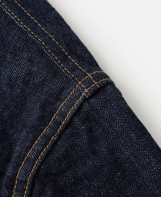 Indigo denim jacket seam with contrast tan topstitching and curved edge