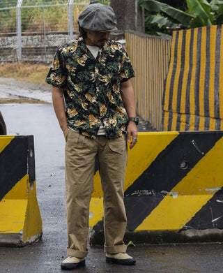 Khaki military trousers on model, full-length leg with cuffed hem