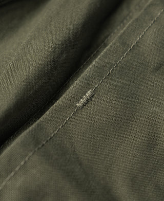 Olive jacket side panel seam detail with zigzag stitching