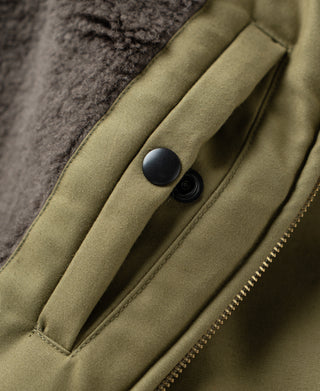 Khaki flight jacket front placket with two buttons and vertical stitched pocket