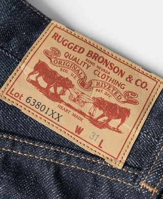 RUGGED BRONSON & CO leather patch on dark denim jeans with cowboy branding