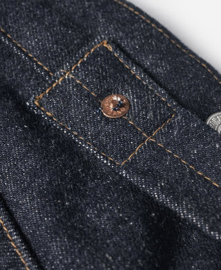 Indigo selvedge denim jeans—copper button at seam with orange-brown topstitching