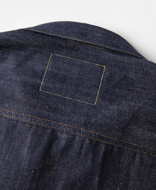 Indigo denim jacket back yoke with rectangular patch and yellow-orange topstitching