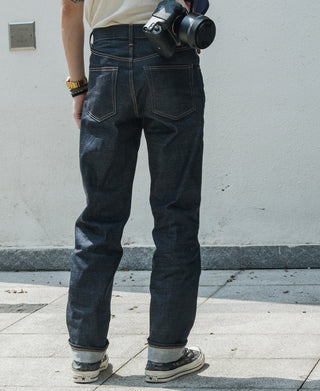 Indigo denim jeans on model, relaxed straight leg with front and back pocket seams