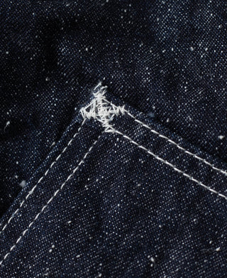 Indigo slub denim seam with bar-tack reinforcement on pocket edge