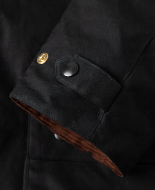Black waxed chore jacket cuff with snap button and fabric tab detail