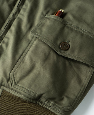 Olive flight jacket chest pocket flap with button and box-stitched corners