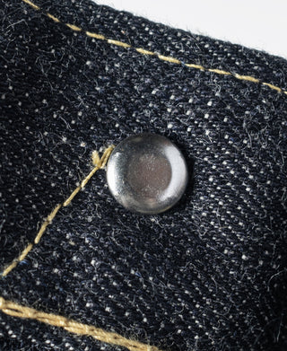 Indigo denim jeans close-up of round metal snap with topstitching
