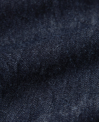 Indigo denim jacket fabric texture with tight weave and subtle speckled pattern