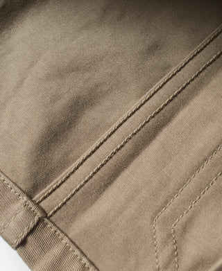 Khaki jacket pocket flap with topstitching and small button detail
