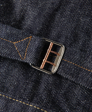 Indigo denim jacket belt loop with metal buckle and gold contrast stitching.