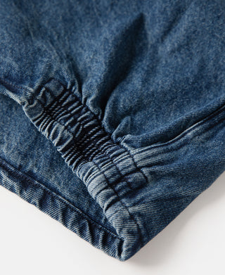 Close-up of indigo denim jacket hem with elastic cinched stitching