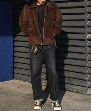 Brown corduroy zip-up jacket with full-length zipper over dark jeans