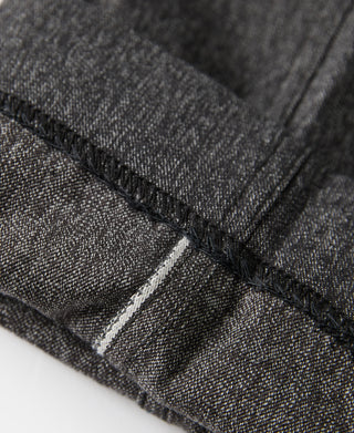 Salt-and-pepper trouser hem with dark stitching and bartack