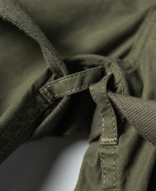 Olive fatigue pants waistband and drawstring tab with stitched straps