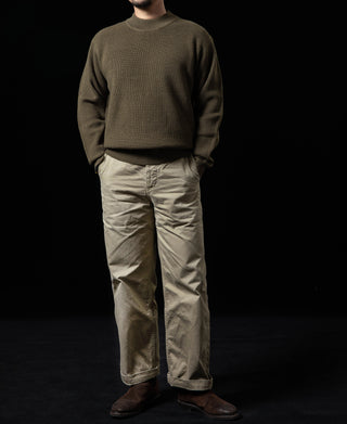 Olive crewneck wool sweater on model with long sleeves and ribbed hem.