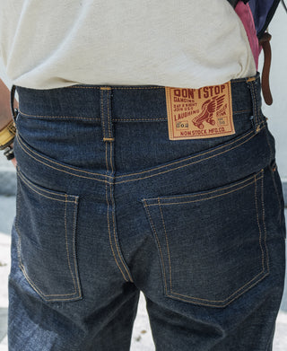 Indigo denim jeans back view with leather-look label and back pocket stitching