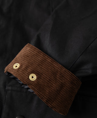 Brown corduroy button cuff on black waxed jacket sleeve