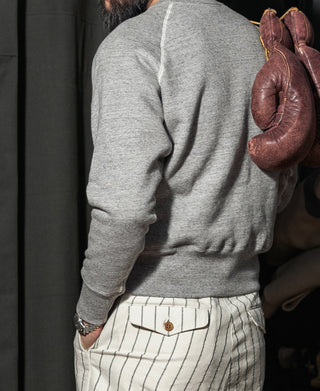 Gray raglan-sleeve sweater, crew neck and long sleeves, side view