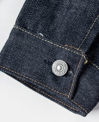 Indigo denim jacket cuff or hem with engraved snap button and selvedge stitching