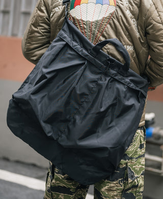 Dark nylon helmet bag with gathered top and large rounded body