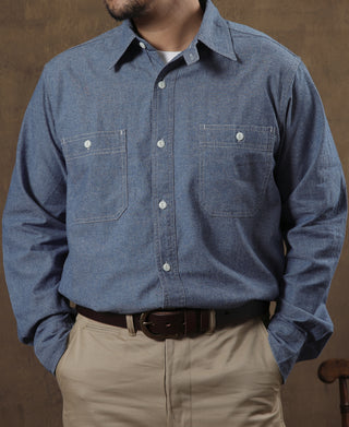 Blue chambray button-up shirt with pointed collar and two chest flap pockets