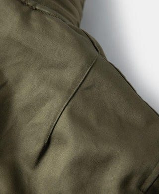 Olive flight jacket side panel with stitched seam detail.