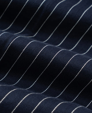 Navy pinstripe fabric with fine texture and repeating white stripe lines
