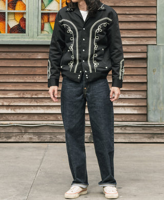 Black musician jacket worn with jeans, embroidered split front panels and high collar