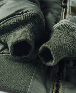 Olive MA-1 flight jacket close-up of ribbed knit cuffs and zipper tape