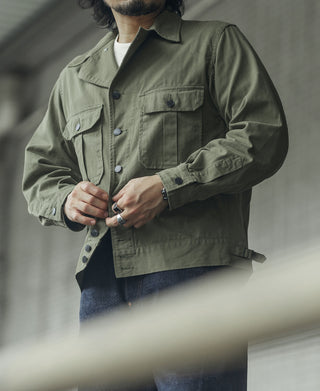 Olive fatigue jacket with two chest pockets, button front, and long sleeves