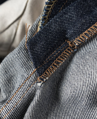 Denim jeans showing selvedge-style side seam and tan contrast stitching