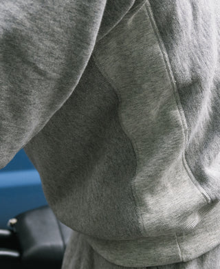 Gray sweatshirt sleeve and side seam detail with ribbed knit cuff
